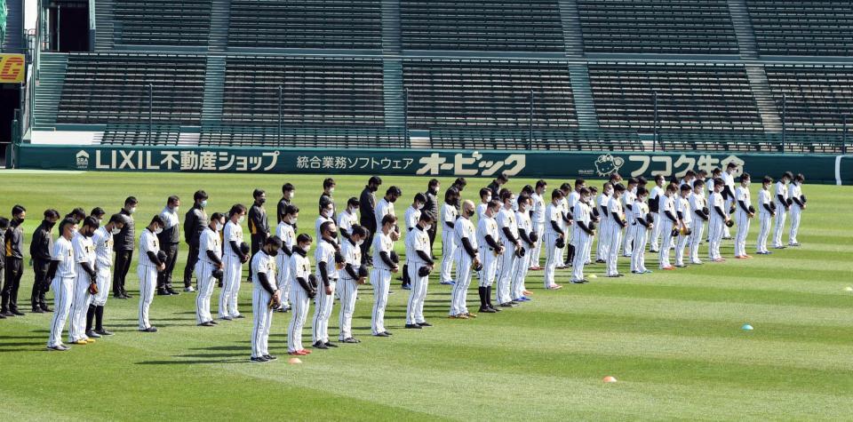 東日本大震災から１０年。阪神ナインは練習前黙とうする＝甲子園（撮影・山口登）