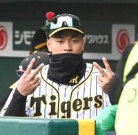 　試合前、ベンチで帽子にバラの花を付けてＶサインの佐藤輝