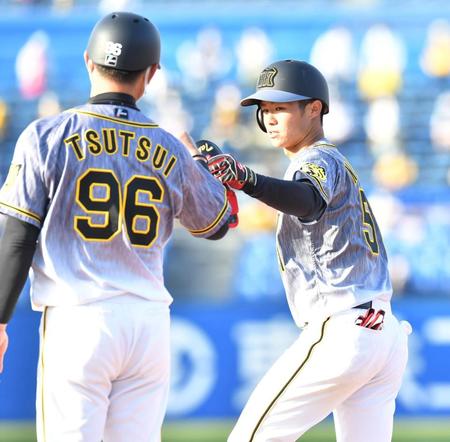 　９回、中前打を放ち、筒井壮コーチ（左）とタッチを交わす阪神・中野拓夢（撮影・西岡正）