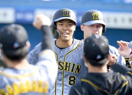 　４回、２ランを放った佐藤輝は笑顔でナインに迎えられる（撮影・田中太一）