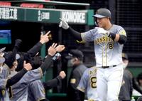 　２回、右越えへソロを放った佐藤輝はナインに迎えられる（撮影・田中太一）