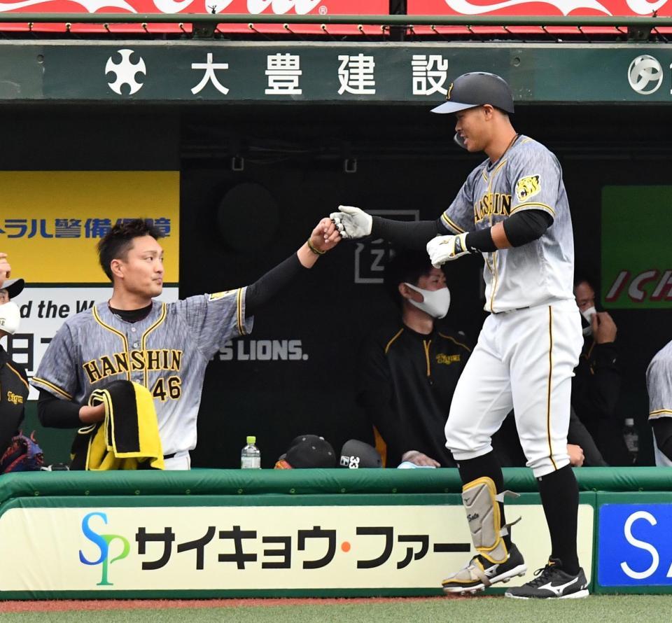 　２回、ソロを放った佐藤輝（右）をタッチで迎える秋山（撮影・高石航平）