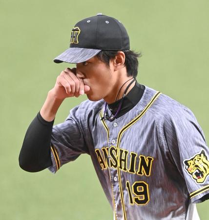 　１回、負傷した右手親指を口にしながらベンチへ戻る藤浪（撮影・飯室逸平）