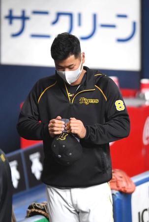 　試合前、帽子のツバを折り曲げようとする阪神・佐藤輝明（撮影・北村雅宏）