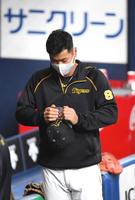 　試合前、帽子のツバを折り曲げようとする阪神・佐藤輝明（撮影・北村雅宏）