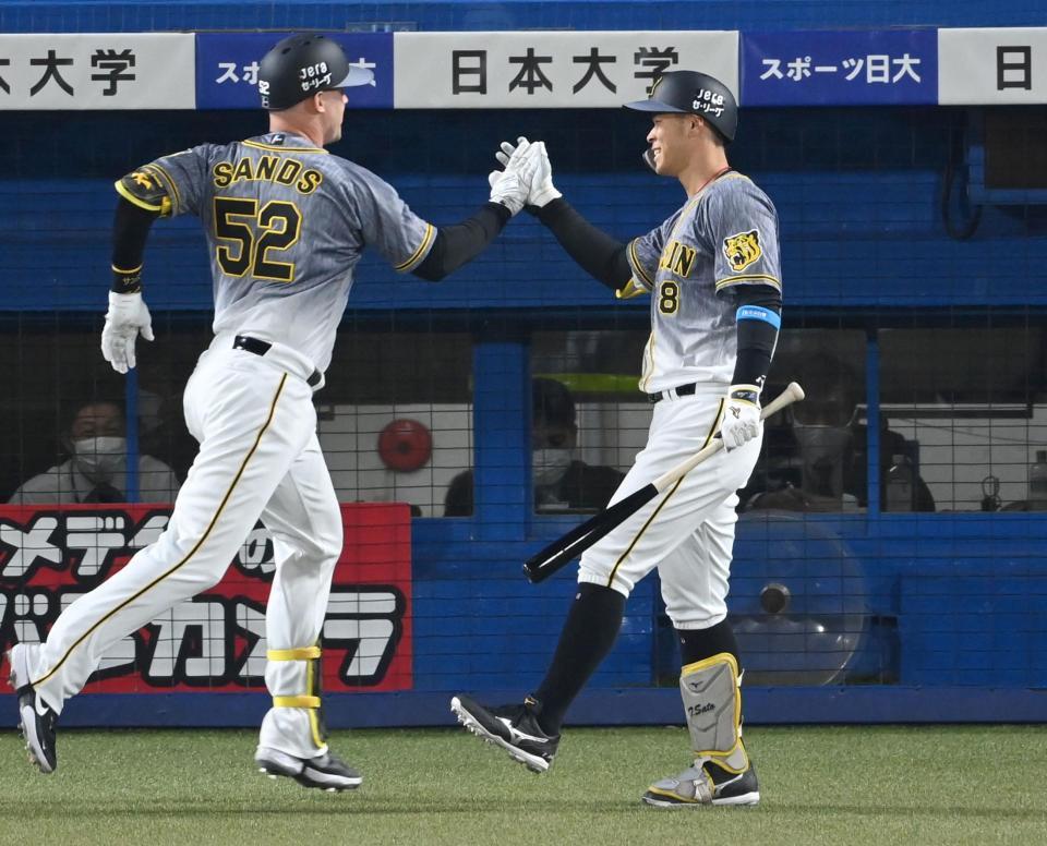 　８回、２号ソロを放ったサンズを迎える佐藤輝（撮影・飯室逸平）