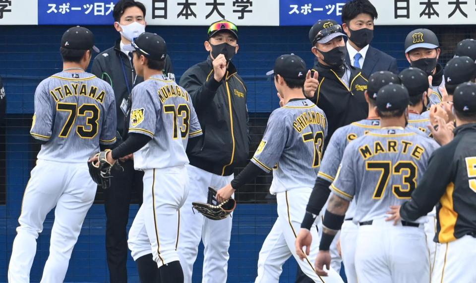 ３連勝を飾り、ハイタッチでナインを迎える矢野監督（中央）＝撮影・飯室逸平