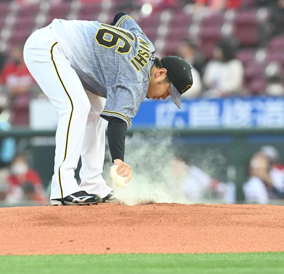 　１回、プレートをロジンではらう西勇（撮影・飯室逸平）