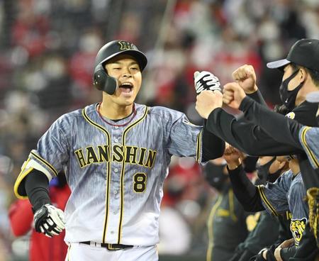 ６回、２号ソロを放った佐藤輝は雄叫びを上げ歓喜のハイタッチ（撮影・飯室逸平）