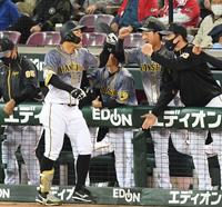 ６回、ソロを放った佐藤輝はナインに迎えられタッチを交わす（撮影・田中太一）