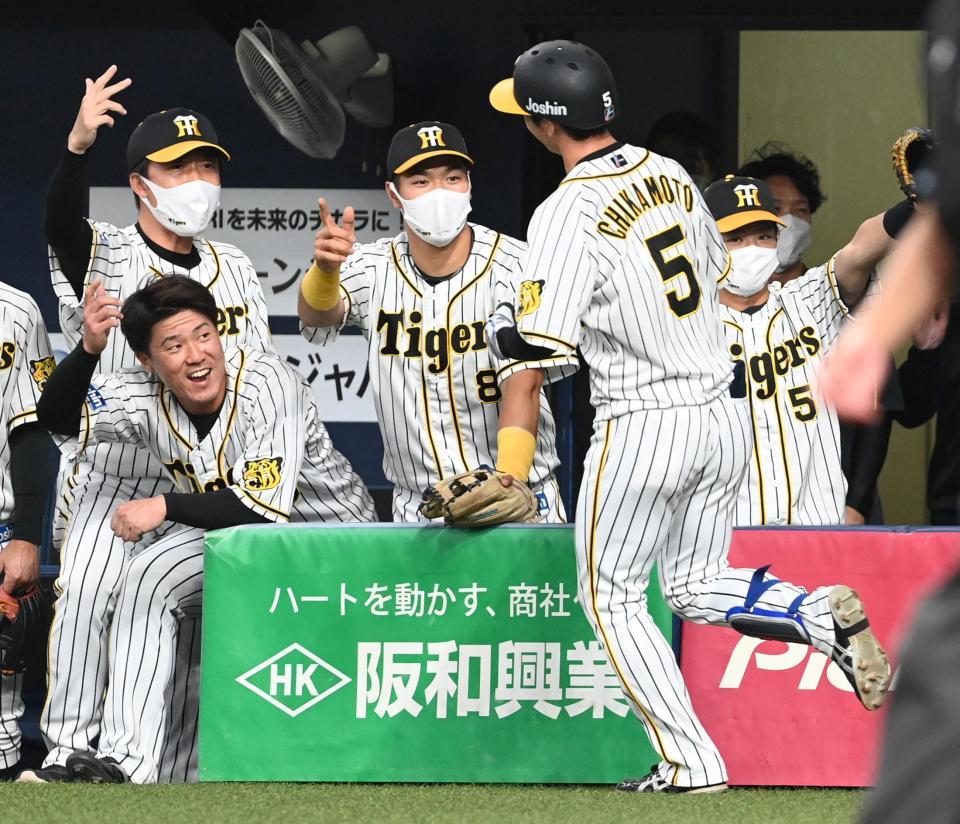１回、先制ソロを放った阪神・近本光司（５）を迎える阪神・佐藤輝明（中央）ら阪神ナイン＝京セラドーム（撮影・飯室逸平）