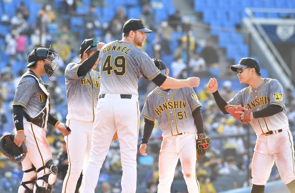 　７回途中、降板となり、ナインとタッチを交わす阪神・ガンケル（中央）（撮影・西岡正）