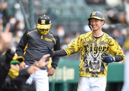 　１回、大山の先制犠飛で生還し、ナインに迎えられる近本（撮影・北村雅宏）