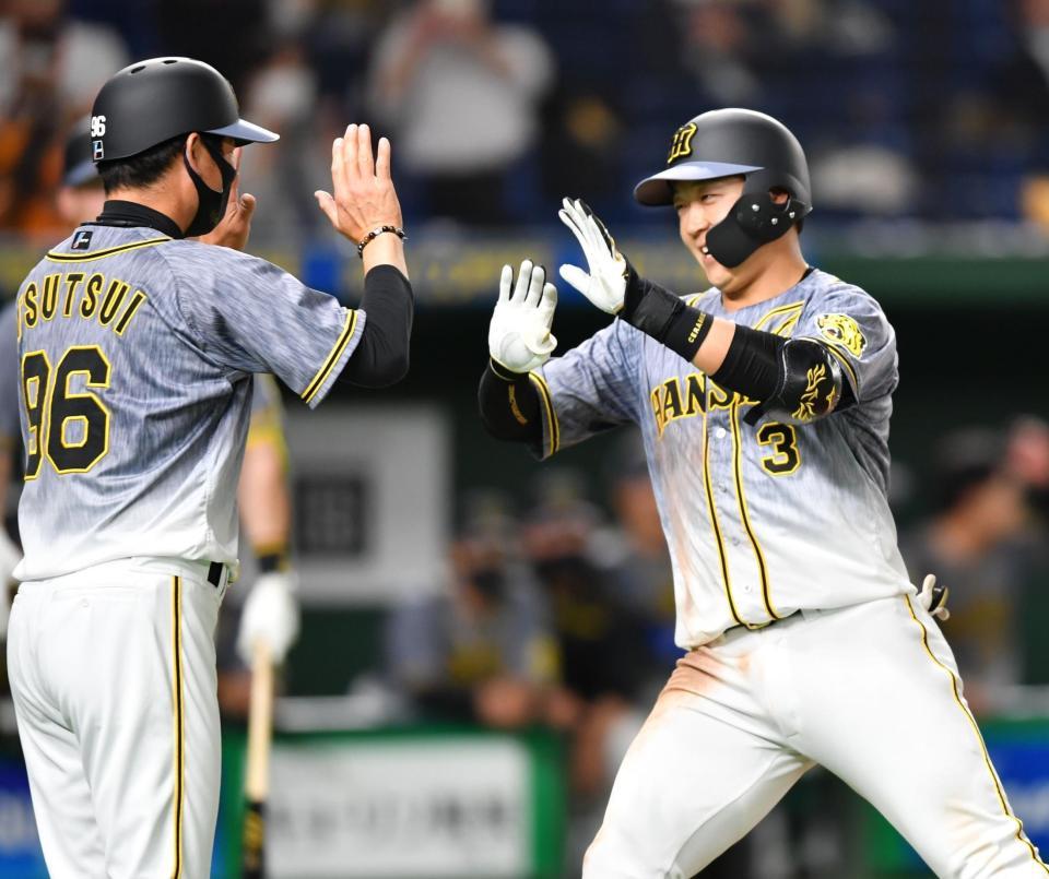 　３回、ソロを放ち、筒井壮コーチ（左）に迎えられる阪神・大山悠輔（撮影・西岡正）