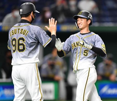 　１回、右越えに先頭打者本塁打を放ち、笑顔で生還する近本（右）＝撮影・西岡正