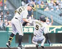 ７回、同点の生還をした阪神・近本光司を笑顔で抱え上げるジェリー・サンズ＝甲子園（撮影・飯室逸平）