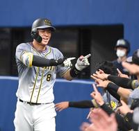 　２回、先制の７号ソロを笑顔で生還する佐藤輝（撮影・飯室逸平）