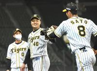 　７回、安部の放った飛球をジャンプして捕球した佐藤輝（８）とグラブタッチを交わす秋山（撮影・北村雅宏）