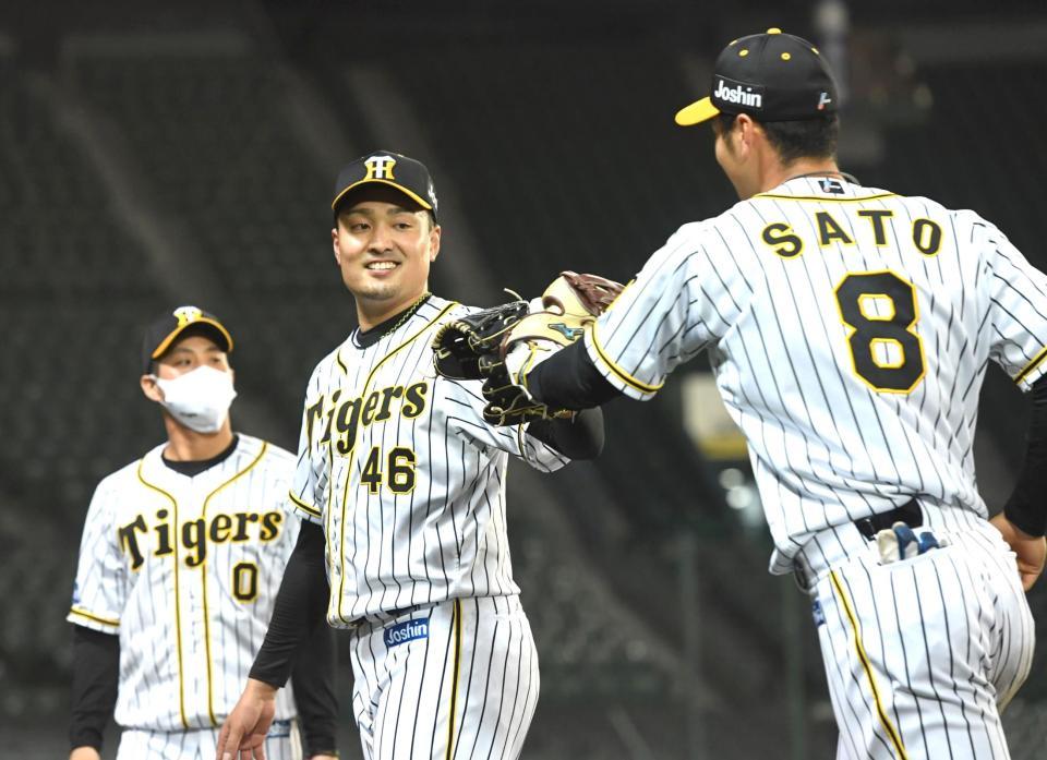 　７回、安部の放った飛球をジャンプして捕球した佐藤輝（８）とグラブタッチを交わす秋山（撮影・北村雅宏）