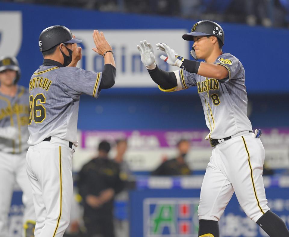 ４回阪神無死、ソロを放ち、筒井コーチに迎えられながら生還する阪神・佐藤輝明（右）（撮影・高石航平）