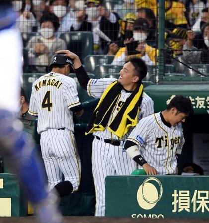 　７回、生還した阪神・熊谷敬宥を迎える阪神・秋山拓巳（撮影・山口登）