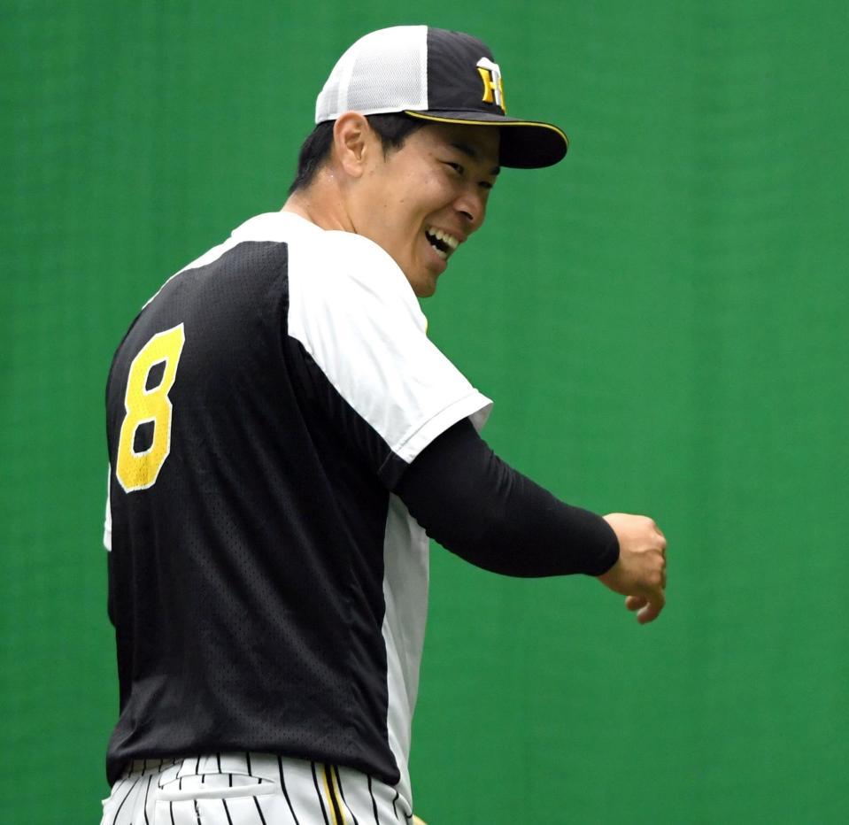 練習中、笑顔を見せる佐藤輝（撮影・山口登）