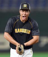 守備ノックでボールを手首に当て、痛がる佐藤輝（撮影・田中太一）