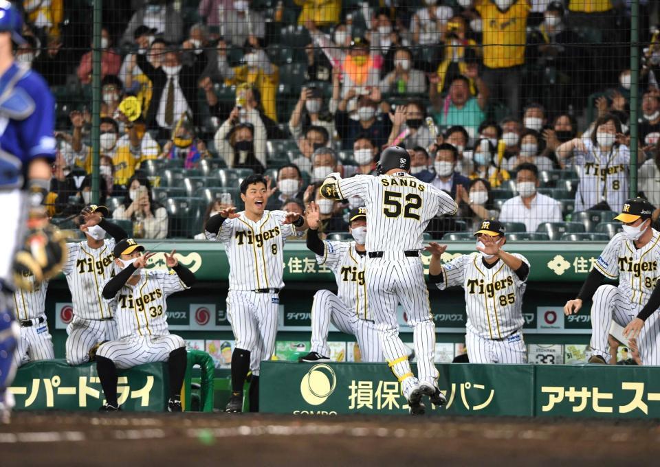 　８回、勝ち越しソロを放ったサンズを迎える佐藤輝（中央）ら阪神ナイン（撮影・山口登）