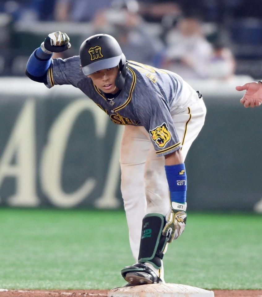 ４回、勝ち越し適時打を放った梅野は塁上で右手をあげる（撮影・田中太一）