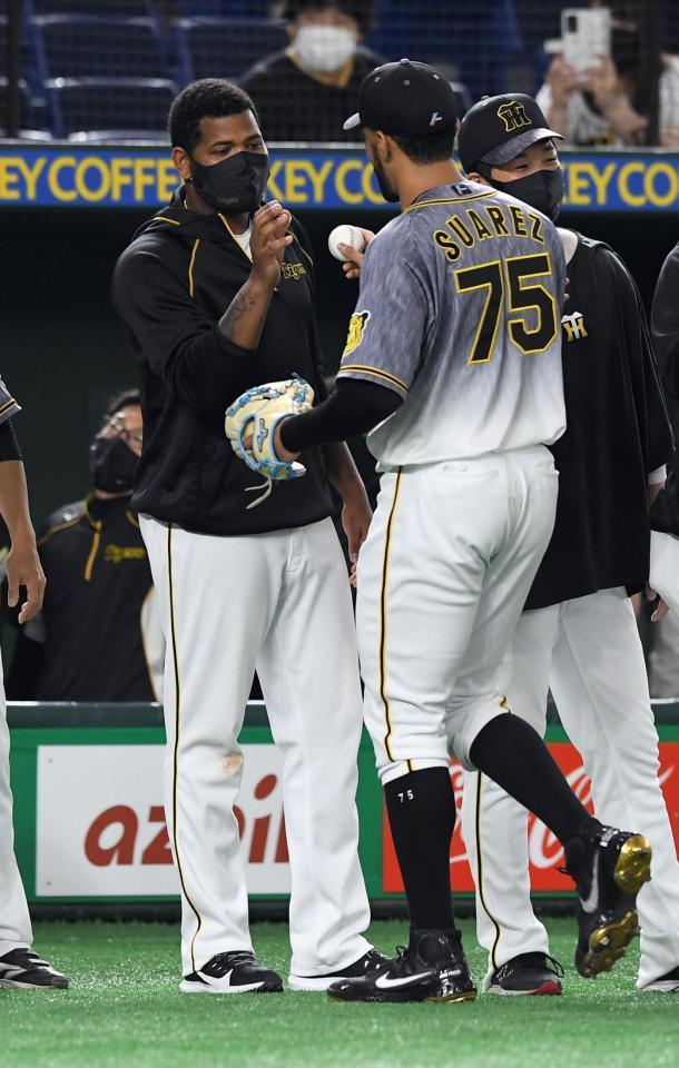 来日初登板初勝利を挙げスアレス（右）からウイニングボールを受け取る阪神・アルカンタラ＝東京ドーム（撮影・佐藤厚）