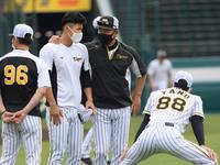 練習前、井上コーチと話をする佐藤輝。右手前は矢野監督（撮影・田中太一）