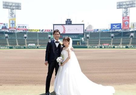 　バックスクリーンを背に撮影する新郎新婦（撮影・田中太一）