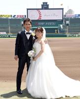 　バックスクリーンを背に撮影する新郎新婦（撮影・田中太一）