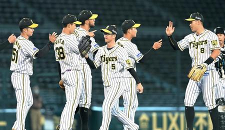 　ロッテに勝利し、タッチを交わす近本（５）、佐藤輝（８）、中野（５１）ら阪神ナイン（撮影・高部洋祐）