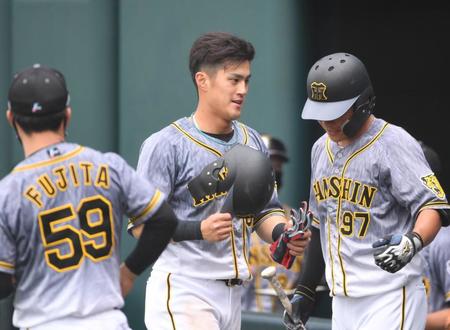 ４回、適時三塁打を放った阪神・板山（中央）は攻撃終了後、ナインに迎えられる＝タマホームスタジアム筑後（撮影・北村雅宏）