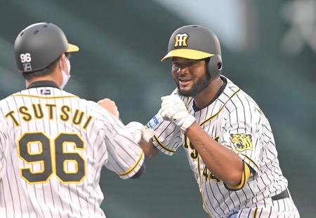 ２回、勝ち越し打を放ち、筒井コーチ（左）とグータッチを交わす阪神・アルカンタラ＝甲子園（撮影・高部洋祐）