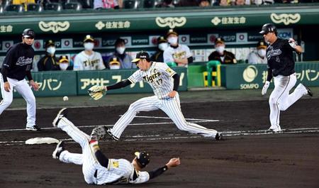 ６回、ロッテ・藤岡の打球を処理した阪神・マルテが一塁へ悪送球し、岩貞が捕球できず勝ち越しを許す＝甲子園（撮影・山口登）