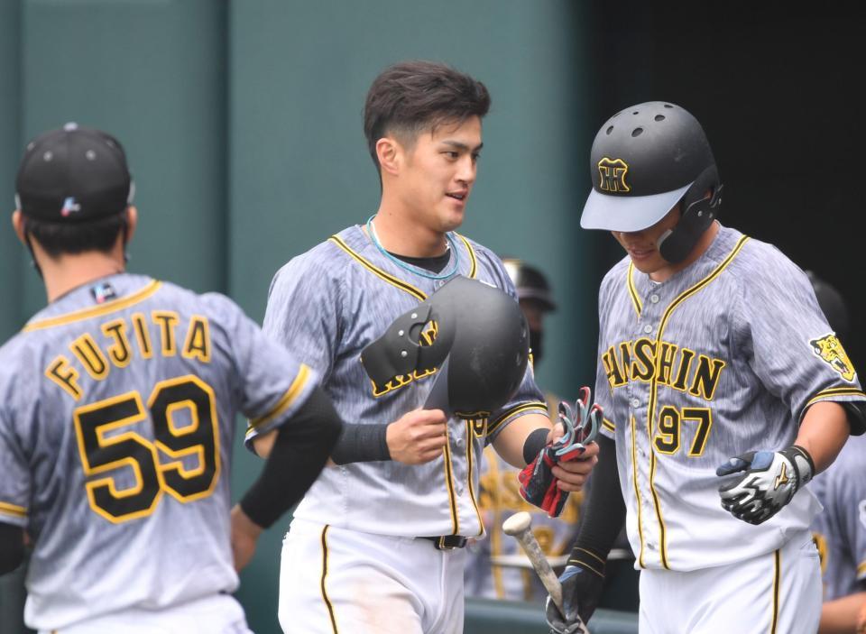 ４回、適時三塁打を放った阪神・板山（中央）は攻撃終了後、ナインに迎えられる＝タマホームスタジアム筑後（撮影・北村雅宏）