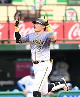 ２回、先制の３号２ランを放ち、両手で天を指さし生還する糸井（撮影・飯室逸平）