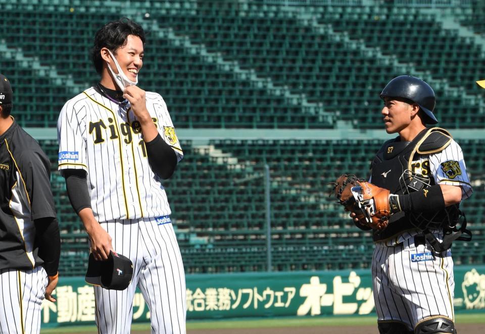 　試合後、バッテリーを組んだ長坂（右）と笑顔で話す藤浪