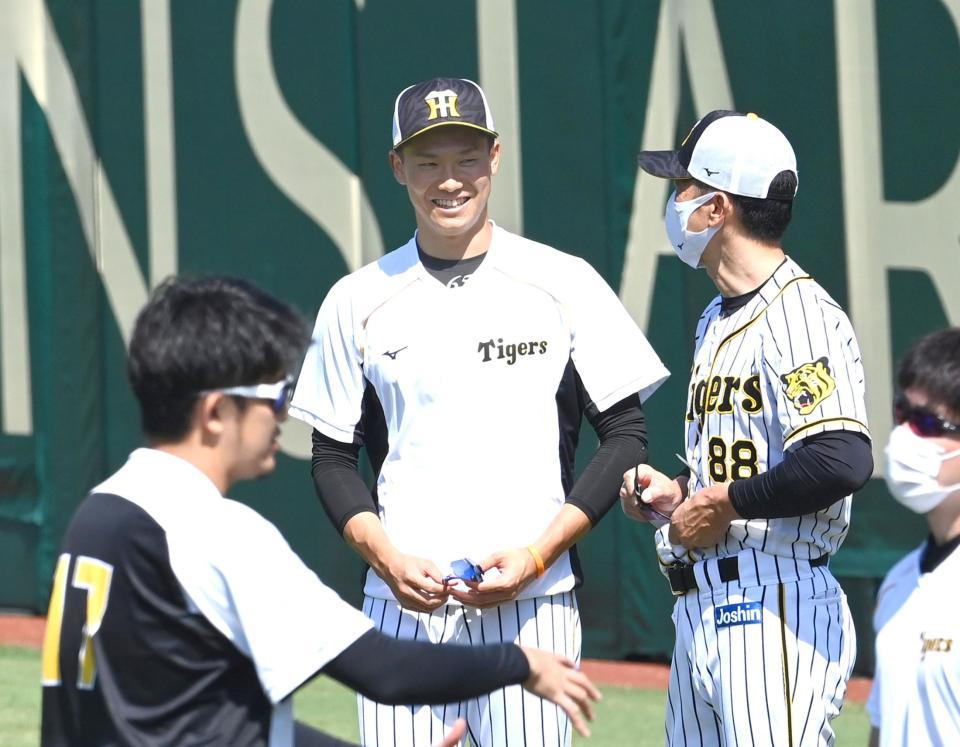 矢野監督に声をかけられ笑顔の湯浅（中央）＝甲子園（撮影・飯室逸平）