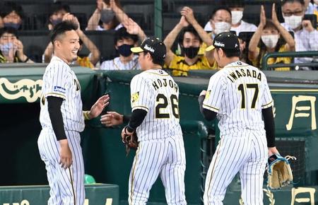 ６回、好リリーフの岩貞（１７）、北條を笑顔で迎える秋山（撮影・飯室逸平）