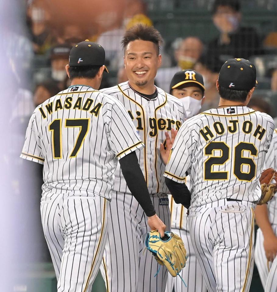 ６回を投げ終えた岩貞（左）を笑顔で迎える秋山（中央）＝撮影・高部洋祐