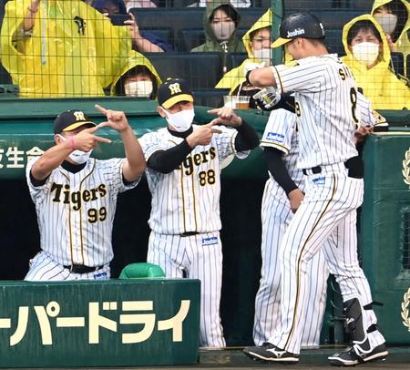 ２回、「Ｚポーズ」で佐藤輝を迎える矢野監督（中央）＝撮影・飯室逸平