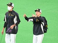 練習前に藤浪（左）と話す小川＝札幌ドーム（撮影・飯室逸平）