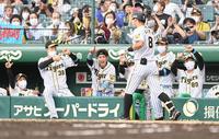 ６回、１７号ソロを放った佐藤輝明を迎える梅野隆太郎（中央）ら阪神ナイン＝甲子園（撮影・飯室逸平）