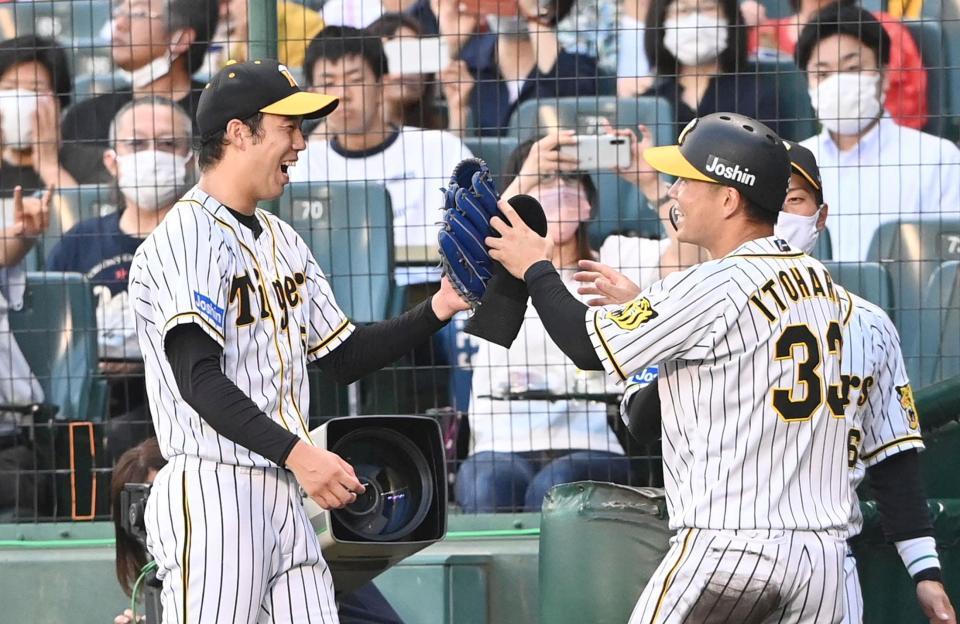 　２回、笑顔で糸原とタッチを交わす青柳（撮影・飯室逸平）