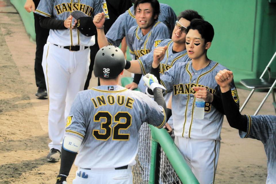 　同点ソロを放ち、ナインに出迎えられる井上