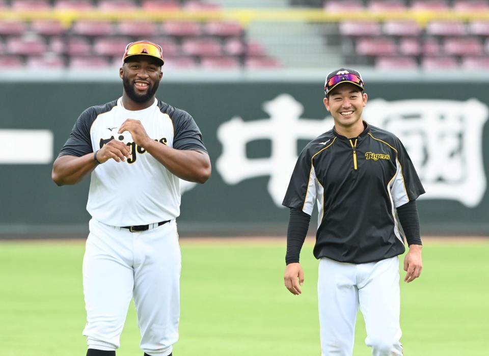 　１軍に合流し、笑顔で話すロハスと山本（撮影・飯室逸平）