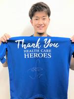 　サイン入りした青色Ｔシャツを手に持つ岩貞（球団提供）